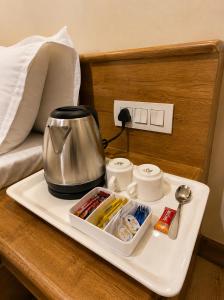 a tray with a coffee maker on a bed at Marawi Desert Resort in Sām