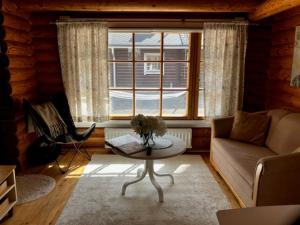 a living room with a couch and a table and a window at Honkahimos 7, Pohjois-Huippu, Jämsä in Jämsä