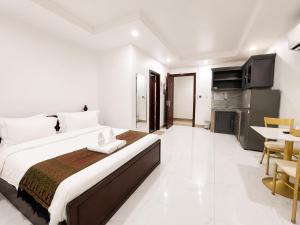 a bedroom with a large bed and a dining room at Try Residence, The Elysée Koh Pich in Phnom Penh