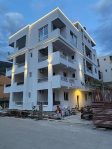 a white apartment building with lights on it at Apartments Pericic LUX in Sutomore