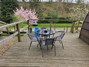 a table and chairs on a wooden deck at Mountain Edge Resort Mega pod 2 with Hot Tub in Church Stretton