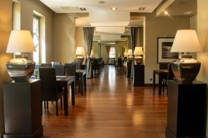 a waiting room with tables and chairs and lamps at Hotel Nowy Dwór Elizy blisko Sky Bridge in Długopole-Zdrój