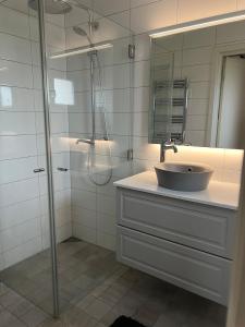 a bathroom with a sink and a shower with a mirror at Skiftehuset in Ytterby +17 photos