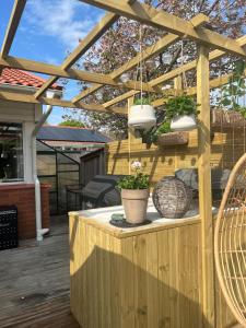 a wooden pergola with potted plants on a deck at Skiftehuset in Ytterby