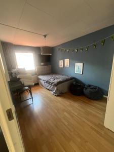 a bedroom with a bed and a chair and a window at Skiftehuset in Ytterby