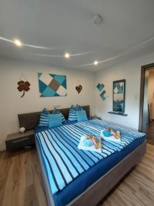 a bedroom with a large bed with blue and white stripes at Ferienwohnung Kasbacher in Bruck an der Großglocknerstraße