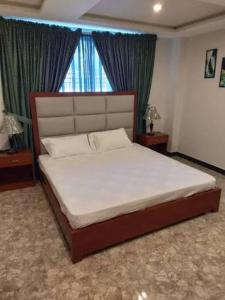 a bedroom with a large bed with a large window at Hotel City Top In Murree in Murree