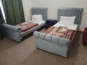 two beds and a couch in a room at Hotel City Top In Murree in Murree