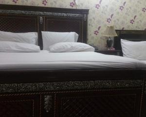 a bed with white sheets and pillows in a bedroom at Hotel City Top In Murree in Murree