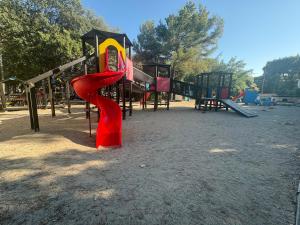 a playground with a red slide in a park at Max Mobile Home in Biograd na Moru