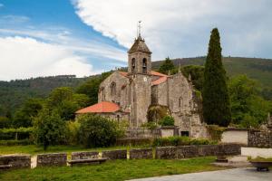 an old church with a clock tower on a hill at A Bodega da Xesteira in Melón