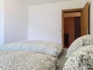 a bedroom with two beds with pillows and a door at Apartment Eben by Interhome in Hippach