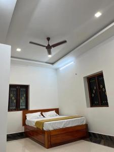 a bedroom with a bed and a ceiling fan at nkm cottage in Rāmeswaram +2 photos