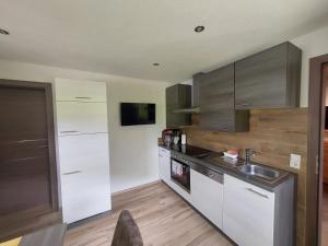 a kitchen with white cabinets and a sink at Ferienwohnung Kasbacher in Bruck an der Großglocknerstraße