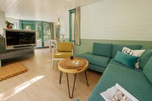 a living room with a blue couch and a table at Center Parcs Erperheide in Peer