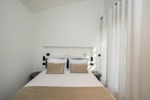a bedroom with a large white bed with two pillows at Kleopatra Homes - Napoleontos in Messini +34 photos