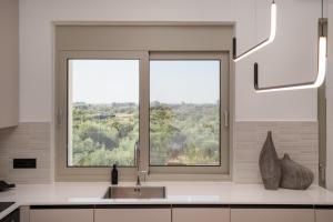 a kitchen with a sink and a large window at Kleopatra Homes - Napoleontos in Messini