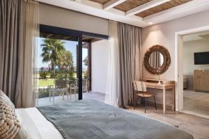 a hotel room with a bed and a desk with a view at Atlantica Beach Resort Kos in Kardamaina +172 photos