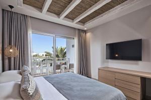 a bedroom with a large bed and a television at Atlantica Beach Resort Kos in Kardamaina