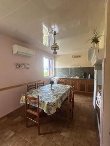 a dining room with a table and chairs and a kitchen at Gîte Prat in Arette