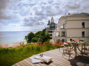 a balcony with a table and chairs and a view of the beach at THE BALTIC VIEW Sellin in Ostseebad Sellin