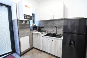 a kitchen with a sink and a black refrigerator at Jivani 105 in Gyumri