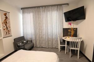 a room with a bed and a table and a television at Jivani 105 in Gyumri
