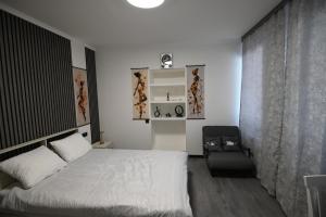 a bedroom with a white bed and a chair at Jivani 105 in Gyumri