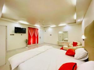 a large bedroom with a large white bed and red pillows at Sun Oasis Resort in Cox's Bazar