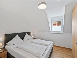 a bedroom with a bed with white sheets and a window at Apartment Laura - S7 by Interhome in Endingen