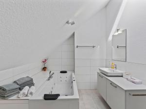 a white bathroom with a tub and a sink at Apartment Nina - 9 by Interhome in Endingen