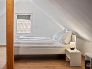 a white bed in a white room with a window at Apartment Nina - 9 by Interhome in Endingen