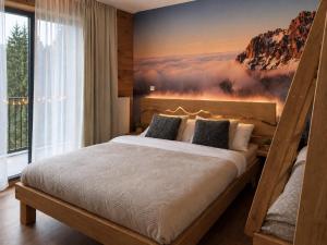 a bedroom with a bed with a painting on the wall at Apartmán Dubový důl in Černý Dŭl
