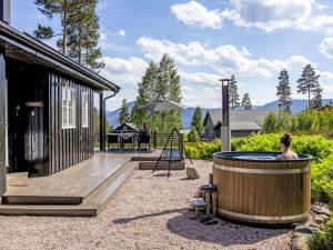 a woman sitting in a hot tub next to a house at Chalet Vrådal by Interhome in Vradal