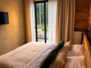 a bedroom with a bed with a view of a balcony at Apartmán Dubový důl in Černý Dŭl +20 photos