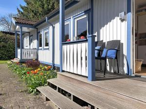 a porch of a house with two chairs and flowers at Apartment Gabi-1 by Interhome in Wiek auf Rügen +10 photos