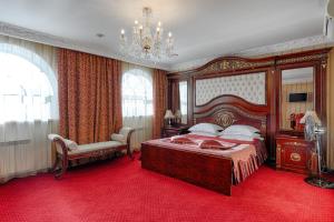 - une chambre avec un grand lit et un lustre dans l'établissement Europa Hotel, à Irkoutsk
