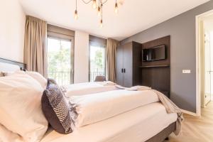 a bedroom with two beds and a tv on the wall at Dormio Resort Maastricht in Maastricht +30 photos