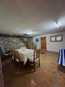 a dining room with a table and chairs and a stone wall at Baita degli Alpini in Terminillo +13 photos