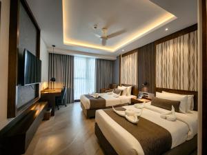 a hotel room with two beds and a desk at Hotel Windy Terrace in Cox's Bazar