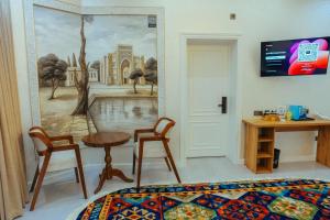 a room with a bed and a table and chairs at Aida hotel PREMIUM in Bukhara