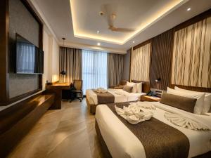 a large hotel room with two beds and a couch at Hotel Windy Terrace in Cox's Bazar