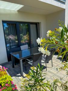 a patio with a black table and chairs and flowers at Villa Corleone in Kąty Wrocławskie