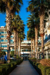 a row of palm trees in front of a building at Adalya Ocean Deluxe - Ultra All Inclusive in Side