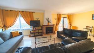 a living room with leather couches and a television at Tango Andaluz - Sunset Ritual Incl in Fuengirola