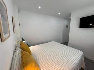 a bedroom with a bed and a flat screen tv at Luxury beach penthouse with Jacuzzi in Fuengirola