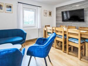 a living room with a blue couch and a table and chairs at Chalet Golden View by Interhome in Janske Lazne