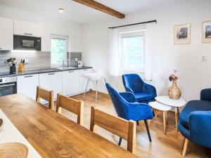 a kitchen and living room with blue chairs and a table at Chalet Golden View by Interhome in Janske Lazne