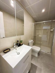 a bathroom with a sink and a toilet and a mirror at Luxury beach penthouse with Jacuzzi in Fuengirola +20 photos