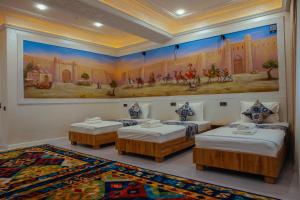 a room with three beds and a painting on the wall at Aida hotel PREMIUM in Bukhara